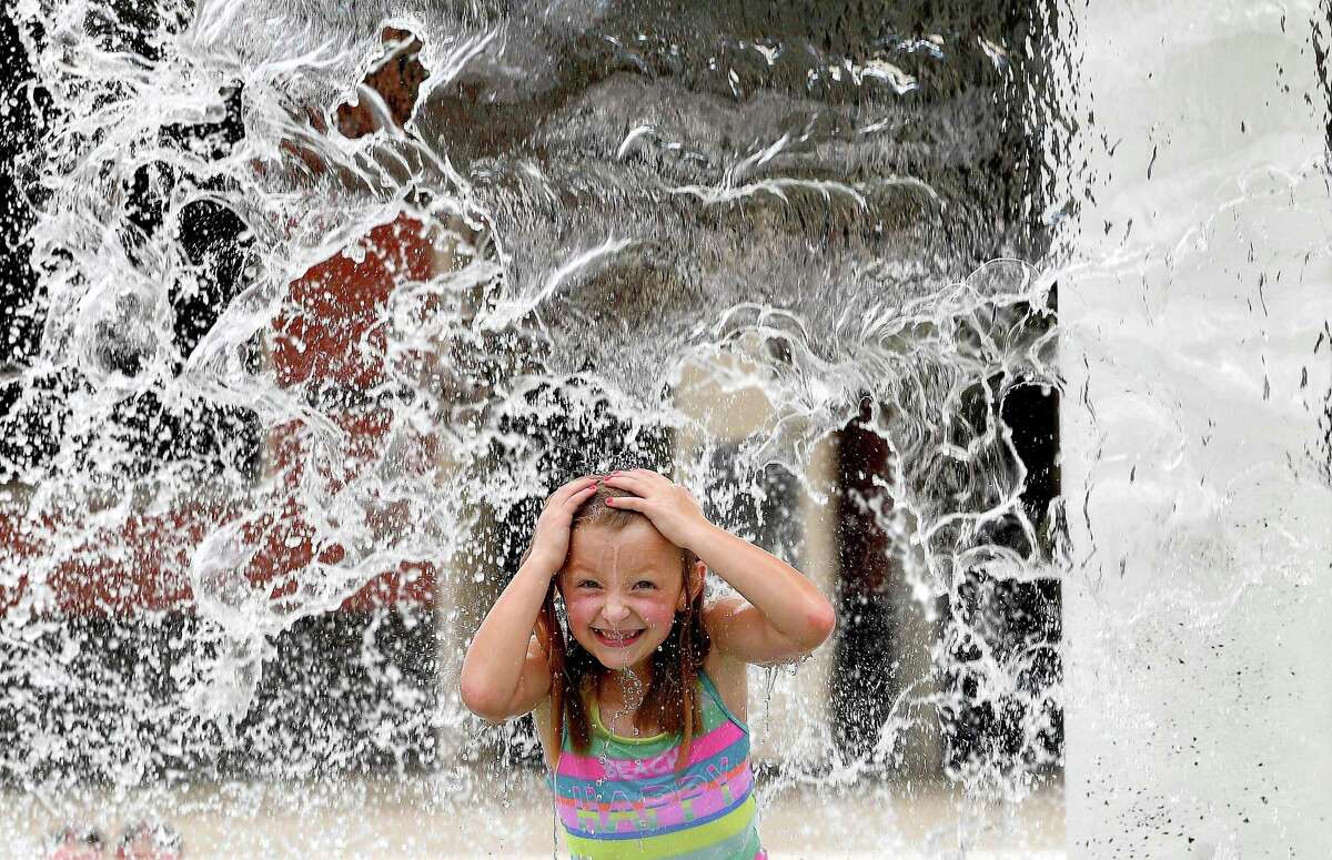 Amelia Cook gets doused in the fountain while cooling off at the Alice Keith Park pool Tuesday, which was the first day of the hottest weeks of summer, according to Space City Weather. Photo made Tuesday, July 27, 2021 Kim Brent/The Enterprise