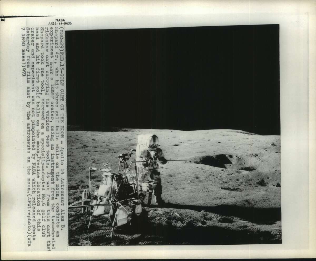 Apollo 14 Astronaut Alan B. Shepard Jr. conducts an experiment near a lunar crater, 1971. 