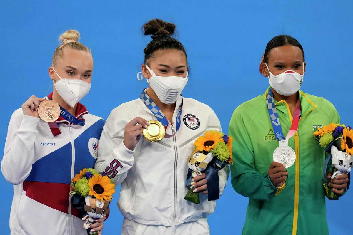 From right to left, silver medallist Brazil's Rebeca Andrade, Gold medallist Sunisa Lee of the Unites States, and bronze medallist Angelina Melnikova, of the Russian Olympic Committee, celebrate during the medal ceremony for the artistic gymnastics women's all-around at the 2020 Summer Olympics, Thursday, July 29, 2021, in Tokyo. (AP Photo/Natacha Pisarenko)