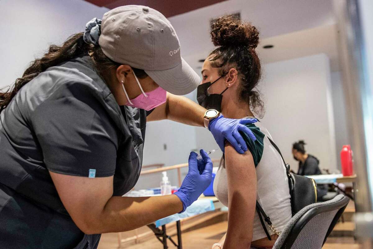 Maxine Grant, right, receives a first dose of the coronavirus vaccine from medical assistant Patricia Ruiz during a popup clinic at the Oakland Zoo.