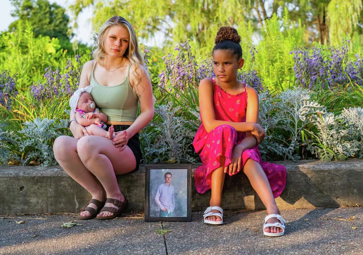 Abigail LeTourneau, left, holds her infant daughter Eliyanna as she sits for a portrait with her sister Adreanna Zavala at Elizabeth Park in Trenton, Michigan on July 27, 2021. Their brother Austin LeTourneau died from a fentanyl overdose in Houston last year. Elizabeth Park was one of his favorite places to visit.