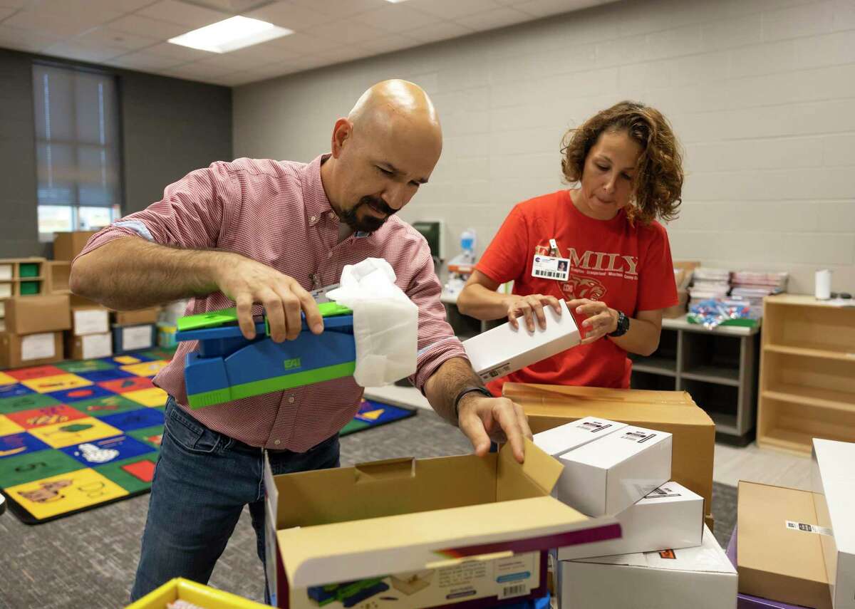 Laura Garza, bilingual kindergarten teacher, right and principal Gilberto Lozano, open boxes in a classroom during a "Pallet Party" in Hope Elementary, Thursday, July 22, 2021, in Conroe. Pallets of supplies were delivered to Hope Elementary to assist teachers and staff in preparation for the upcoming school year.