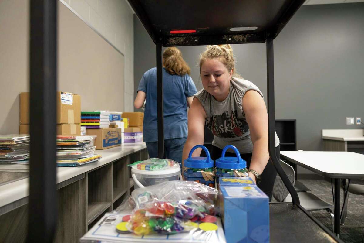 Kaitlin Springer, kindergarten teacher. grabs boxes of supplies in a classroom during a "Pallet Party" in Hope Elementary, Thursday, July 22, 2021, in Conroe. Pallets of supplies were delivered to Hope Elementary to assist teachers and staff in preparation for the upcoming school year.