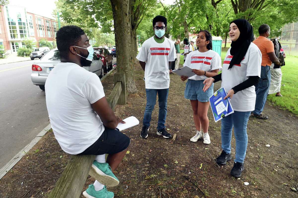 From left, Aaron Moody of New Haven listens to Public Health College Corps members Taylor Munroe Kripa Patel and Nour Al Zouabi at De Gale Field in New Haven on July 29, 2021 about passing along literature concerning COVID-19 vaccinations to friends and family. The Public Health College Corps is a collaboration between Quinnipiac University and the Connecticut Department of Public Health to train college students to address vaccine hesitancy and bring that information to communities with low vaccination rates in the state.