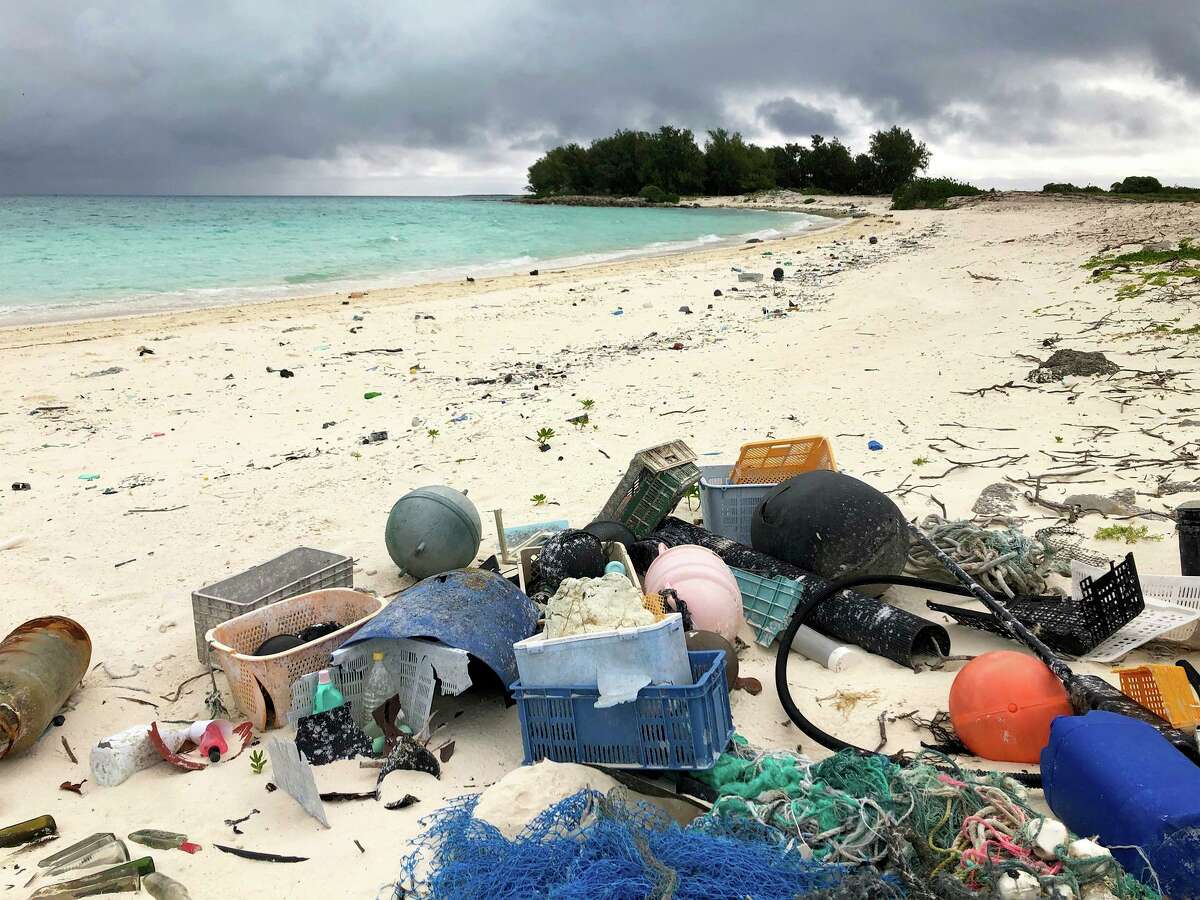 FILE - In this Oct. 22, 2019, photo, plastic and other debris sits on the beach on Midway Atoll in the Northwestern Hawaiian Islands. According to a study released on Friday, Oct. 30, 2020, more than a million tons a year of America's plastic trash isn't ending up where it should. The equivalent of as many as 1,300 plastic grocery bags per person is landing in places such as oceans and roadways. (AP Photo/Caleb Jones)