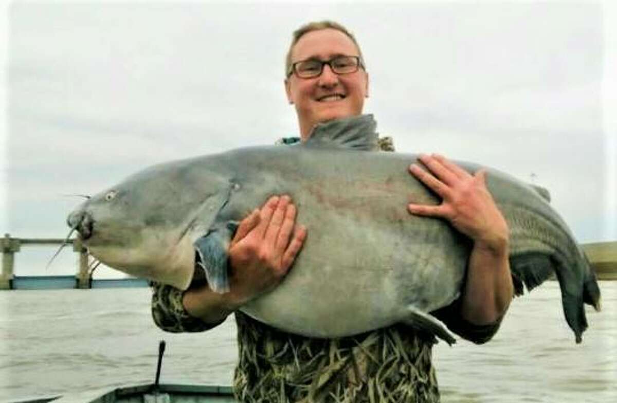 Madison County Deputy Treasurer Patrick McRae holds a 90-pound blue catfish he caught on the Mississippi River. McRae and his father, Circuit Clerk Tom McRae, are encouraging participation in National Fishing Month in August. For more information visit https://www.nationalfishingmonth.com/.