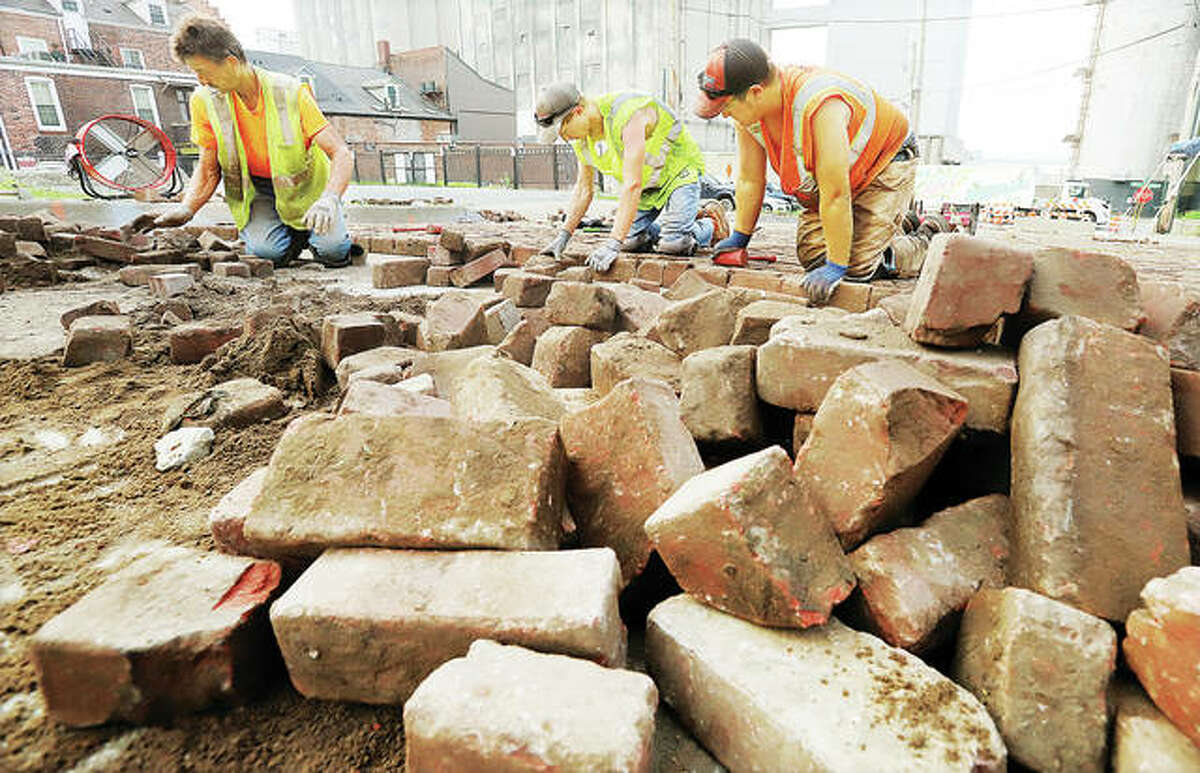 Stutz Excavating, Inc., workers on Thursday were replacing the bricks — one at a time — on Williams Street in Alton. The street was repaired from damage caused in the Flood of 2019. Williams Street is on a list of “protected” streets designated by the Alton City Council that requires bricks to be replaced after any repair.