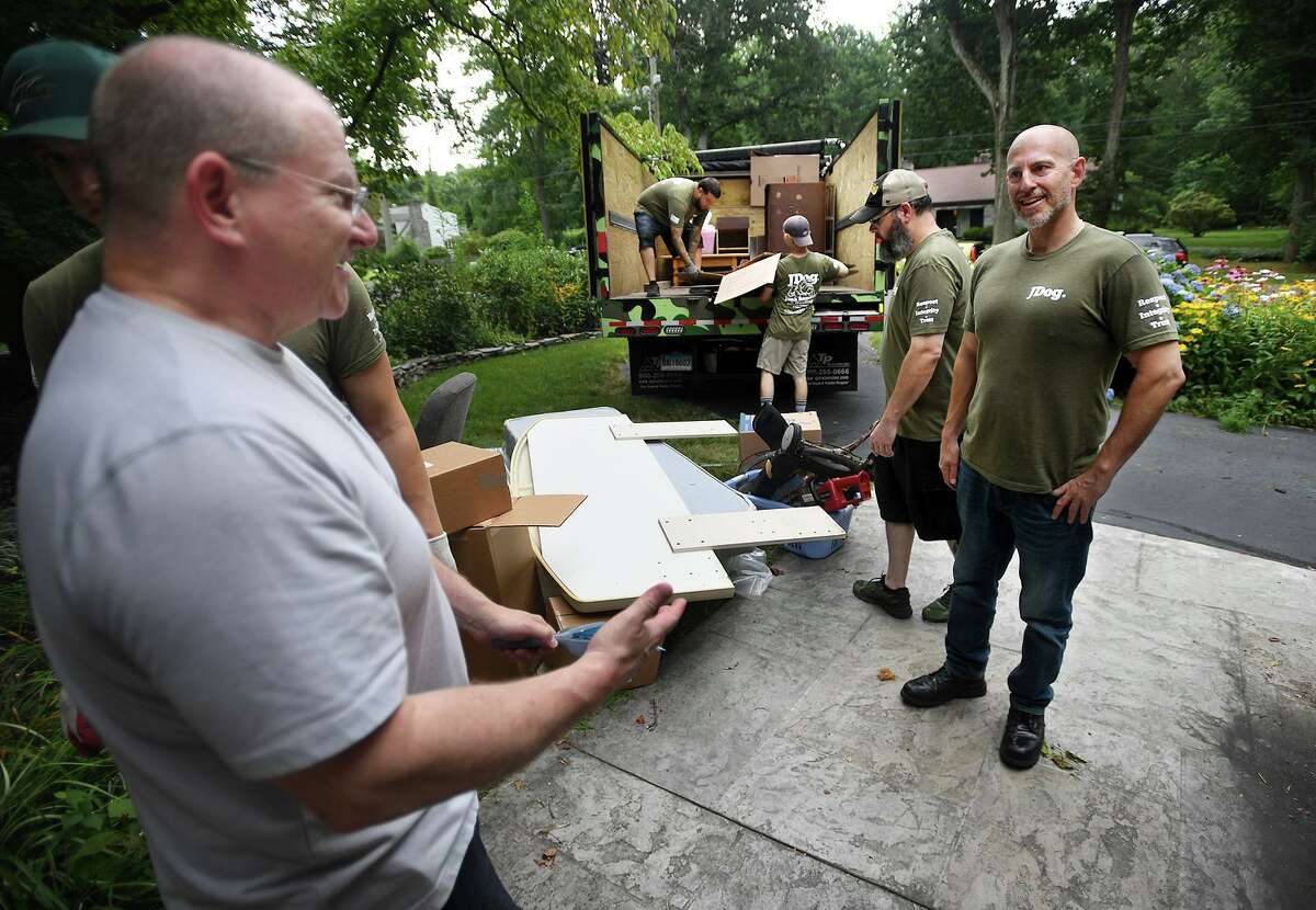 JDog owner Sean-Michael Green, right, chats with client William Murray as his crew of military vets clears out Murray's home in preparation for sale in Milford, Conn. on Thursday, July 29, 2021.