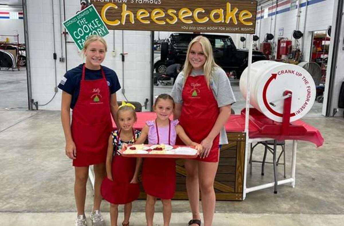 Lily Freer, left, and Taylor Freer, right, with little helpers Thursday at the annual Christmas in July event, which kickstarts annual fundraising for Community Christmas, sponsored by The Telegraph and the United Way.