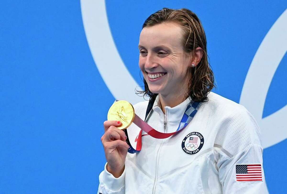 Katie Ledecky shows off her medal from the women’s 800-meter freestyle, her third gold from that race.