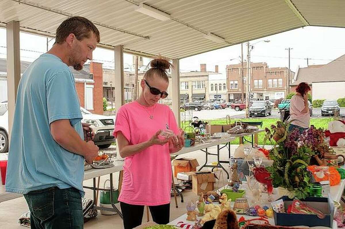 Brett Baird (left) and Jessica Falzone look at some of the items for sale Friday during a Centenary United Methodist Church fundraiser to benefit its Bell Project. The project involves hanging the church’s original, 1-ton bell over a newly constructed entrance to the church at 331 E. State St. and is slated to be completed by October.