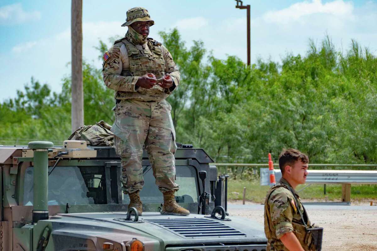 Two Texas National Guardsmen watch the border at Del Rio last July.