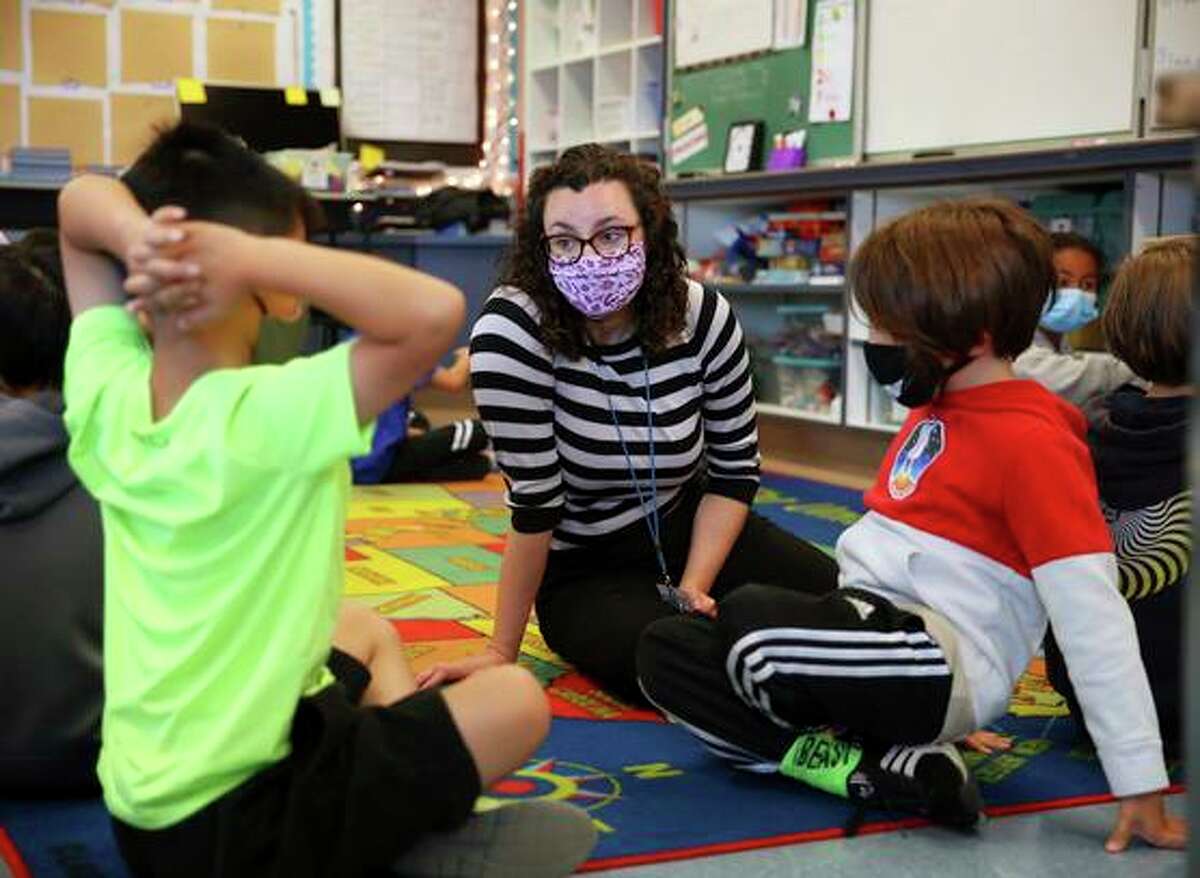 Fourth-grade teacher Erin Flathers talks with students as they work in pairs during a morning class exercise at Argonne Elementary School.