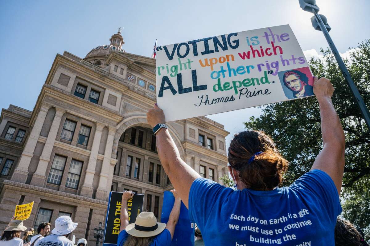 AUSTIN, TEXAS - JULY 31: People display signs during the Georgetown to Austin March for Democracy rally on July 31, 2021 in Austin, Texas. Texas activists and demonstrators rallied at the Texas state Capitol after completing a 27-mile long march, from Georgetown to Austin, demanding federal action on voting rights legislation. (Photo by Brandon Bell/Getty Images)