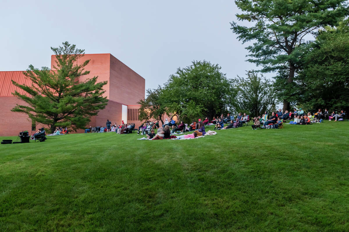 People settle on blankets to watch an outdoor movie on Saturday, July 30, 2021 at Dow Gardens. (Adam Ferman/for the Daily News)