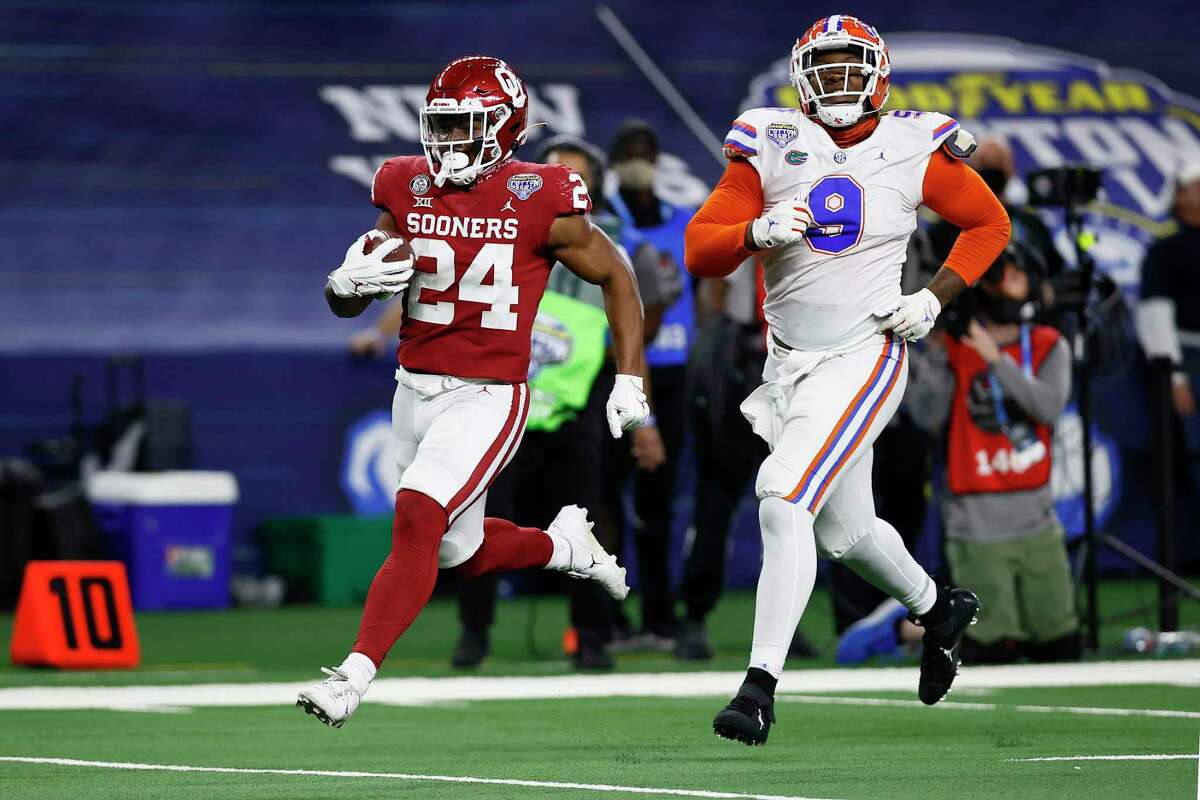 ARLINGTON, TEXAS - DECEMBER 30: Running back Marcus Major #24 of the Oklahoma Sooners runs for a touchdown against defensive lineman Gervon Dexter #9 of the Florida Gators during the fourth quarter at AT&T Stadium on December 30, 2020 in Arlington, Texas. (Photo by Tom Pennington/Getty Images)