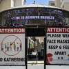 In this June 11, 2021, file photo, signs with social distancing guidelines and face mask requirements are posted at an outdoor mall amid the COVID-19 pandemic in Los Angeles.