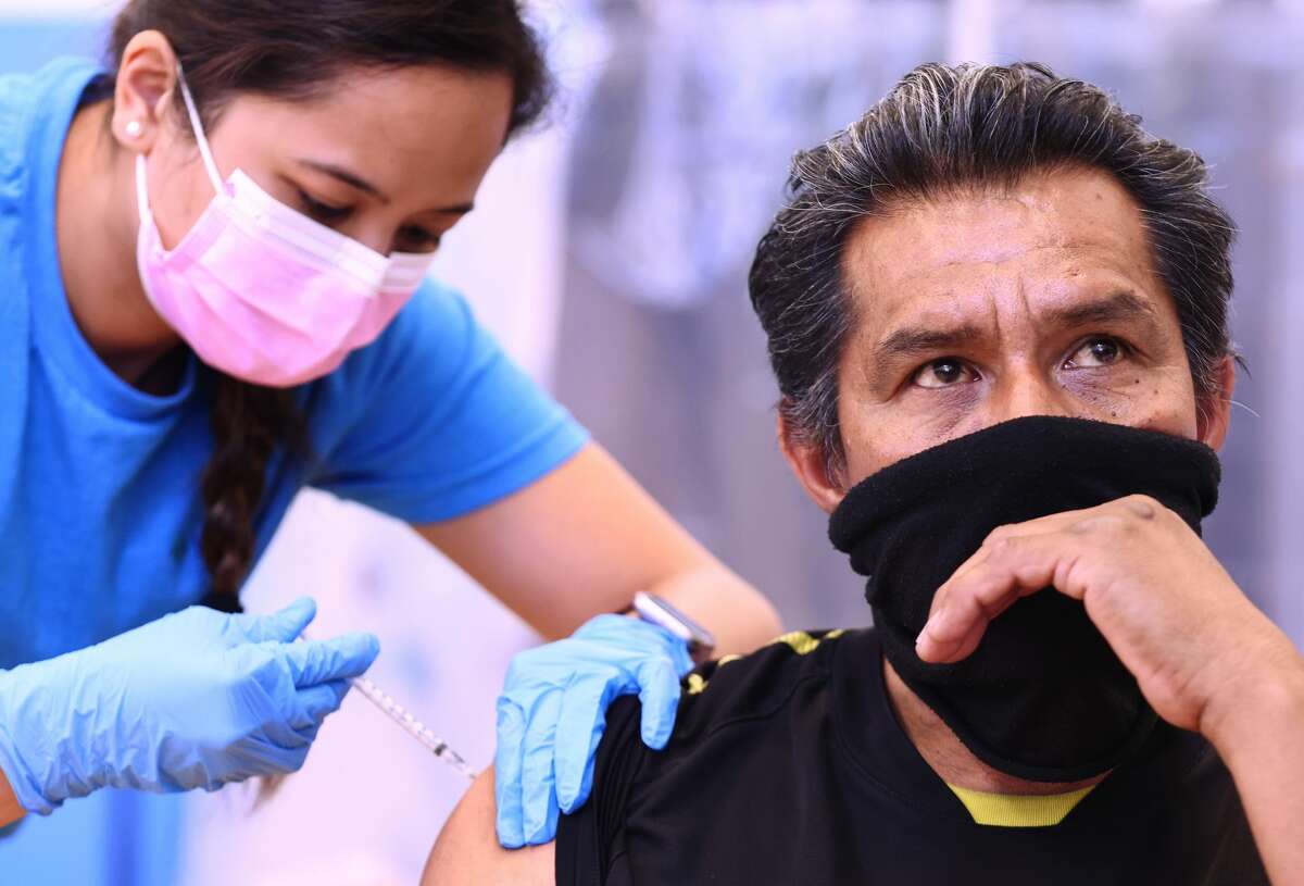Registered nurse Darryl Hana administering a dose of the Pfizer COVID-19 vaccine to a person at a three-day vaccination clinic at Providence Wilmington Wellness and Activity Center on July 29, 2021 in Wilmington, California.