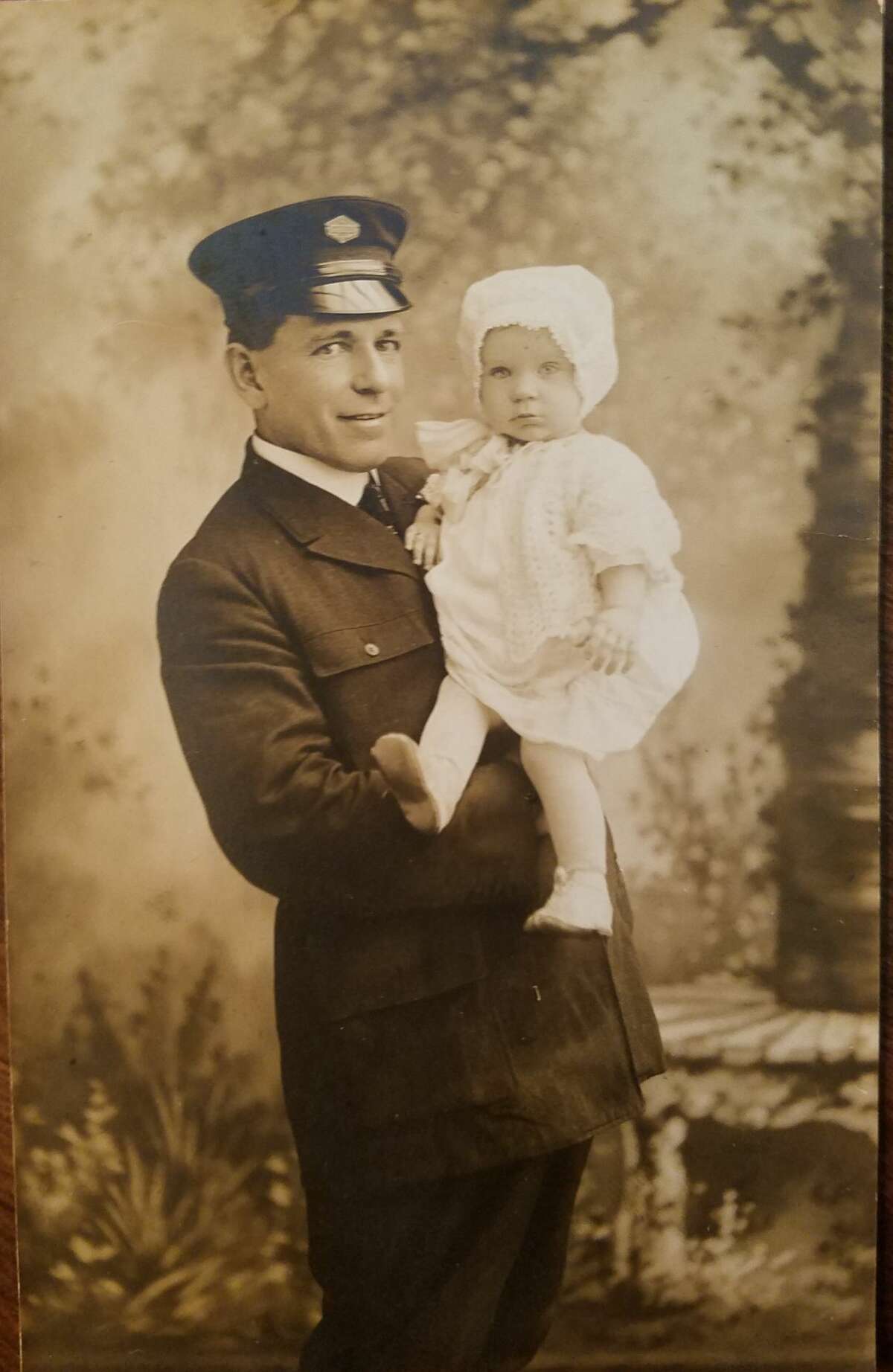 Thomas Goggins, valet and chauffeur to the Mathews family, holding his baby daughter Georgette  circa 1920