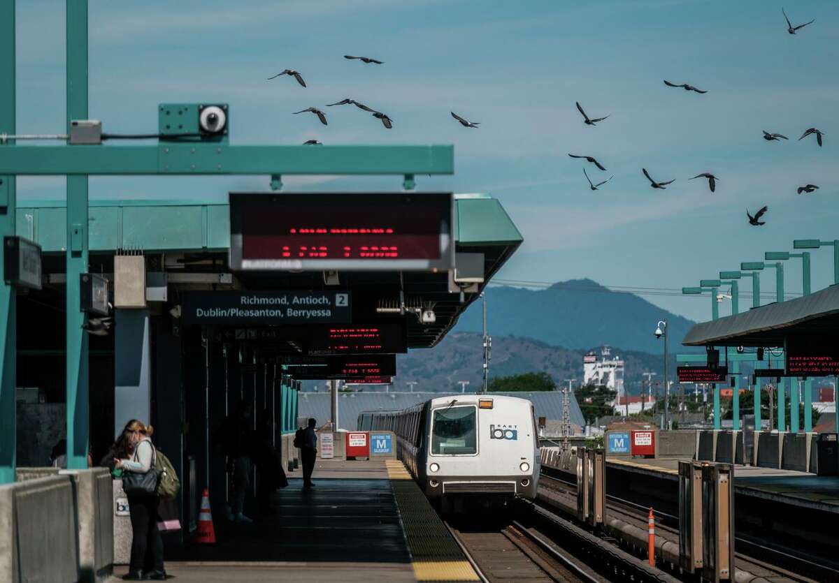 Riders are seen waiting for trains at the West Oakland BART Station in Oakland on Monday.