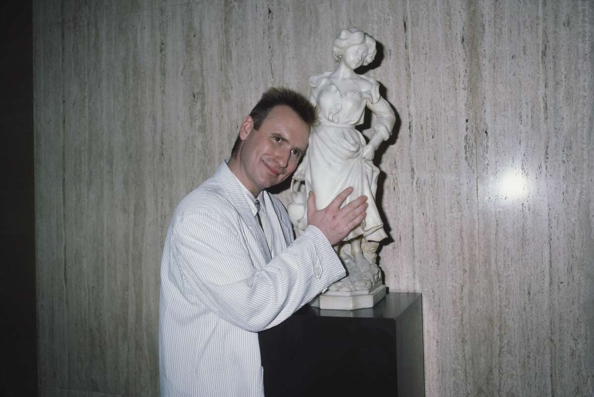 British-Australian singer-songwriter and musician Colin Hay, frontman with Men at Work, poses beside a statuette of a woman at the 5th Annual American Video Awards, held at the Scottish Rite Auditorium in Los Angeles, California, 26th February 1987.