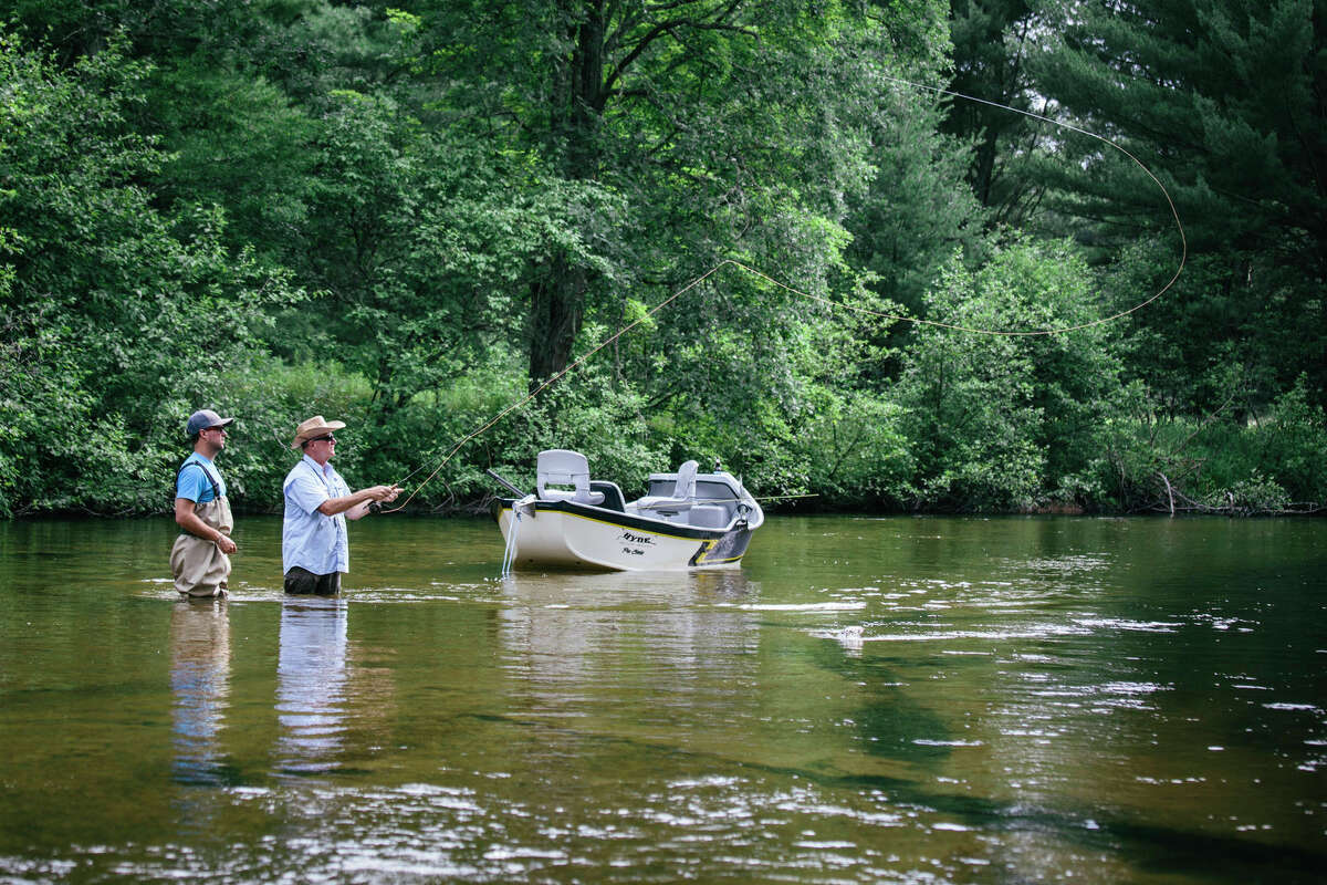 Two men are pictured fly fishing on the Pere Marquette River.