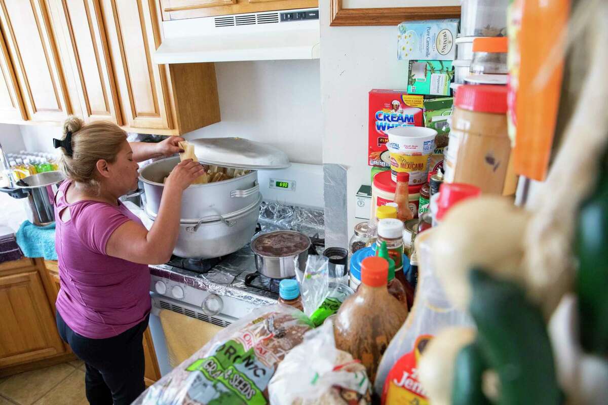 Victoria Medina prepares tamales in the one-bedroom Mission District apartment she shares with her three children. Lately, she says more people in the neighborhood are selling food to make ends meet.