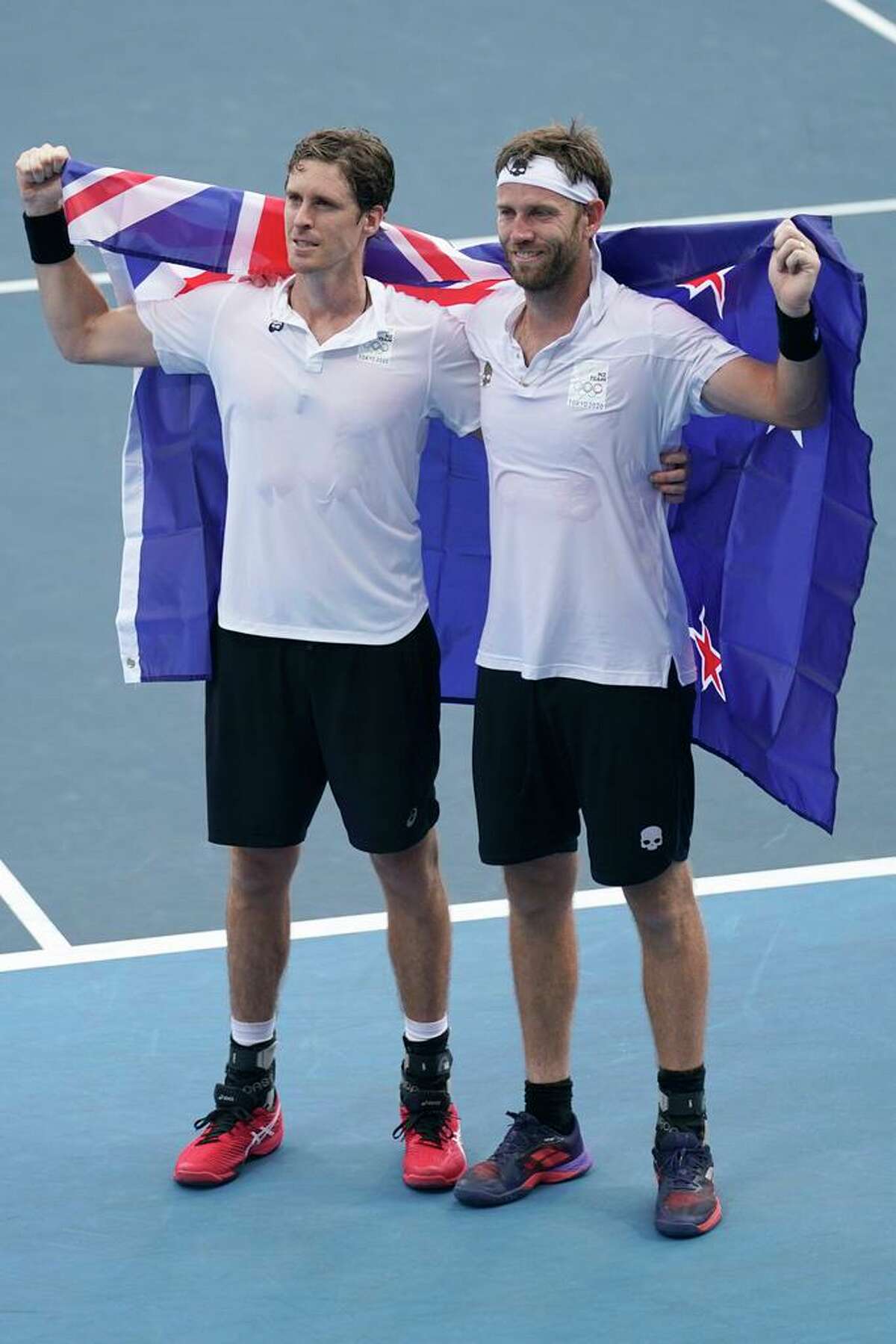 The New Zealand doubles team of Michael Venus, right, and Marcus Daniell celebrate with the flag of their country after defeating the team from the United States during the men's doubles bronze medal match of the tennis competition at the 2020 Summer Olympics, Friday, July 30, 2021, in Tokyo, Japan. Daniell practiced in Salisbury, Conn. during the pandemic.