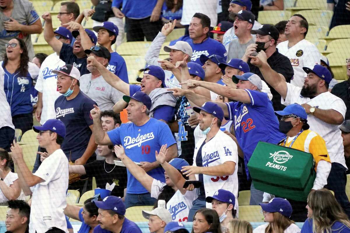 Fans gesture toward the Houston Astros' dugout during the first inning of the Astros' baseball game Los Angeles Dodgers on Tuesday, Aug. 3, 2021, in Los Angeles. (AP Photo/Marcio Jose Sanchez)