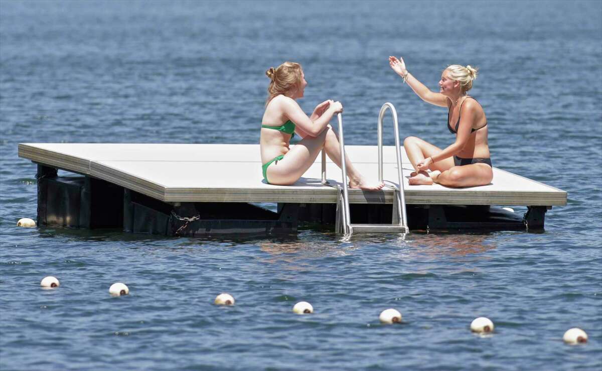 Grace Federle, left, 16, and Lilly Hoeniger, 17, both of Washington, enjoy a day off in the sunshine on a float at the Washington Town Beach on Lake Waramaug in 2017. Litchfield County on Tuesday joined the rest of the state in having “substantial” threats of COVID-19 spread.