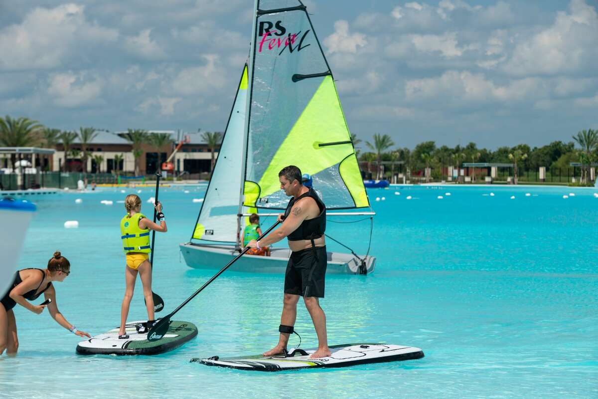 Stand-up paddle boarders test the waters of the National Sailing Club at Lago Mar. The club offers members and nonmembers access to sailboats, single and tandem kayaks and an electric boat that seats 12.