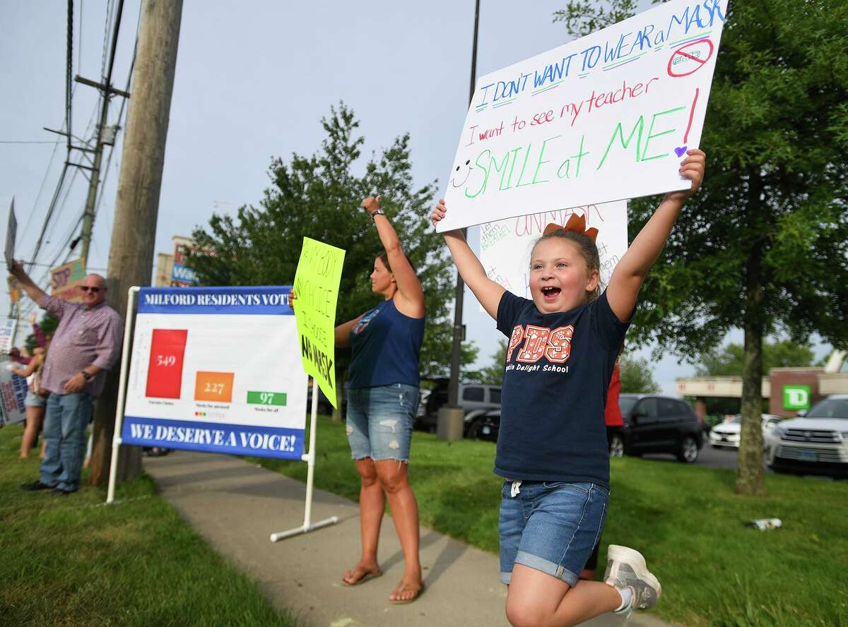 Lucia Andrews, 6, right, of Milford, enthusiastically participates in an Unmask Our Kids rally on the Post Road in Milford, Conn. on Tuesday, August 3, 2021. The rally was organized by the Facebook group's Milford chapter.