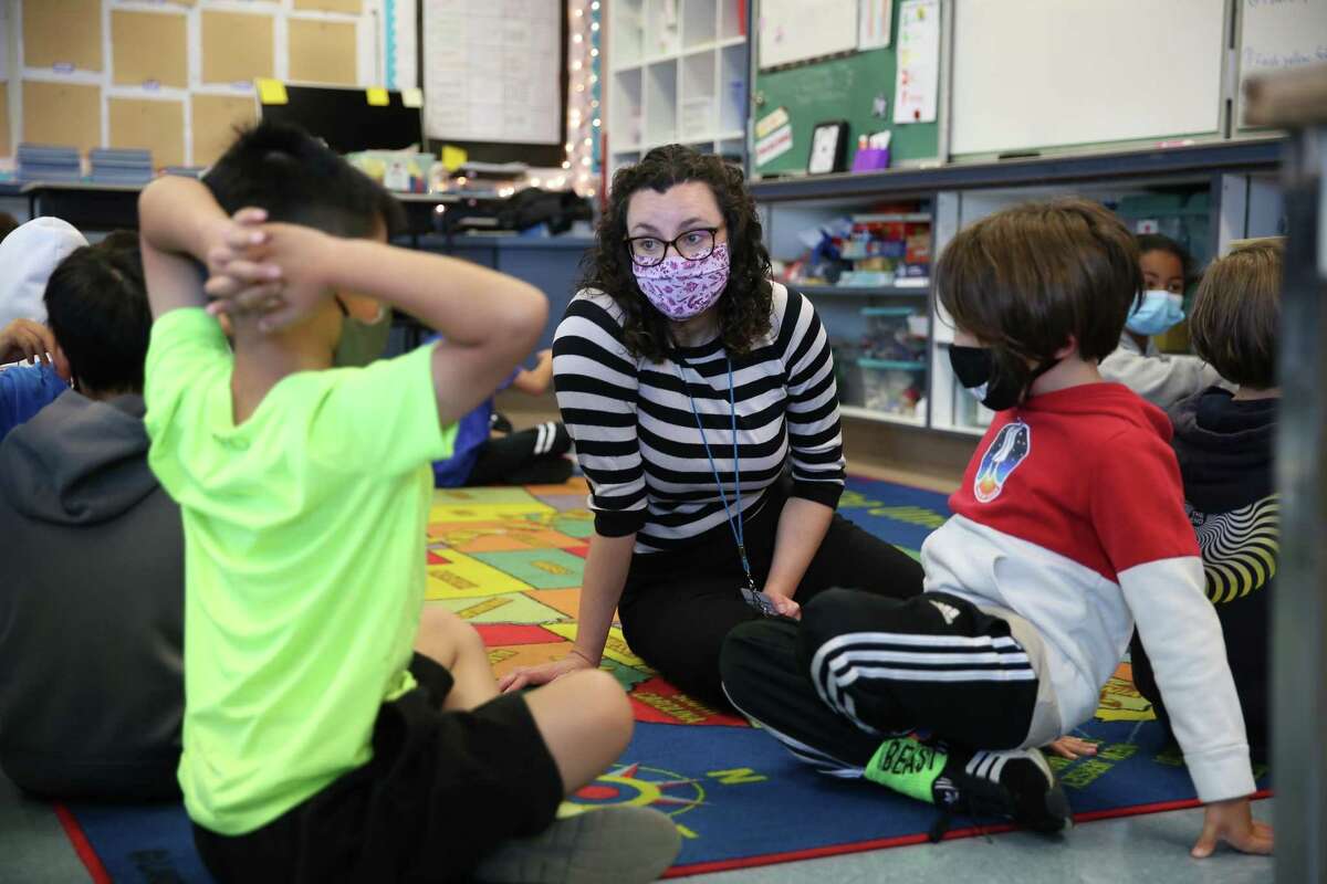 Fourth-grade teacher Erin Flathers talks with students as they work in pairs during a morning class exercise in the classroom on the first day that Argonne Elementary School was back in class in July.