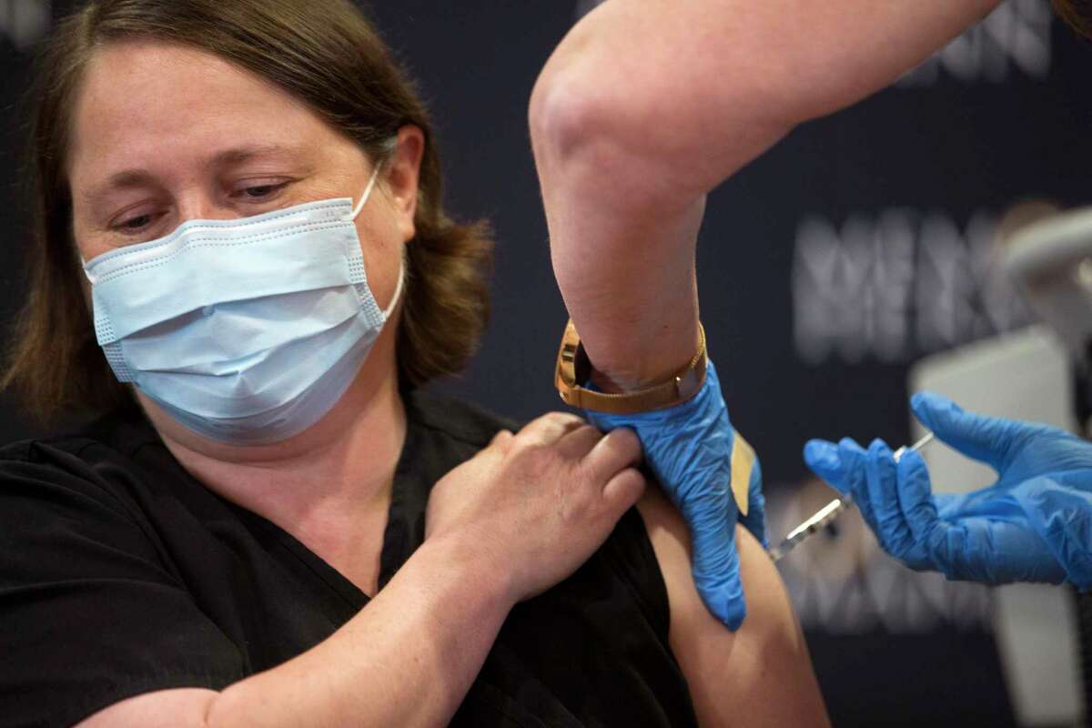 Dr. Linda Yancey, infectious disease specialist, receives a dose of the Pfizer-BioNTech vaccine for COVID-19 from Mindy Warren Tuesday, Dec. 15, 2020 in Houston. (Brett Coomer/Houston Chronicle via AP)