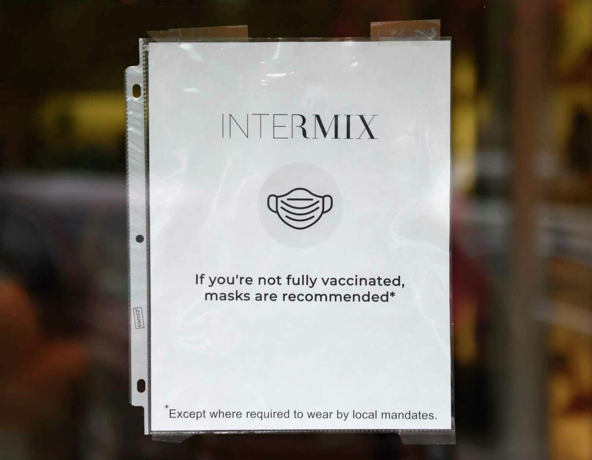 A sign recommends masks at Intermix in Greenwich, Conn. Thursday, Aug. 5, 2021. COVID cases are on the rise again and the state Department of Health has recommended that anyone over the age of 2 wear a mask indoors regardless of vaccination status.