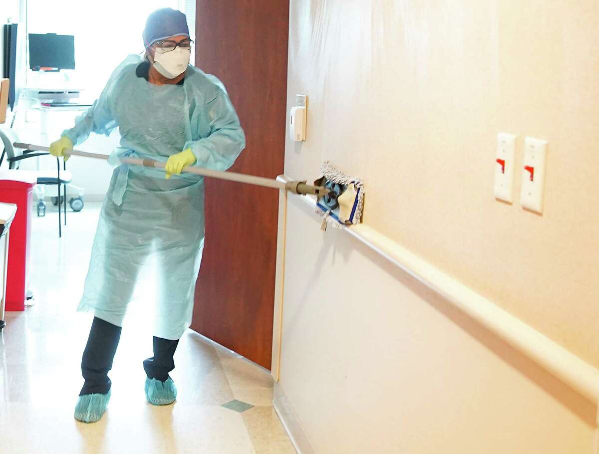 Zoila Gongora cleans a room in the COVID wing after a patient was transferred to a different floor at Houston Methodist Continuing Care Hospital in Katy on Tuesday, Aug. 3, 2021.