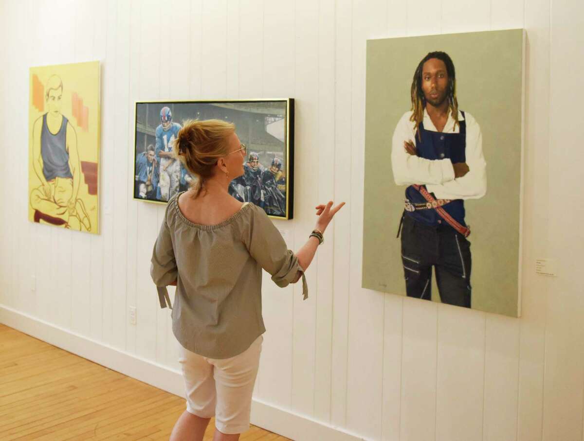 Greenwich Art Society Co-Director Mary Newcomb looks at Lindy Blanchard's painting "Lemuel" at the Greenwich Art Society's 104th Annual Juried Exhibition at the Bendheim Gallery in Greenwich, Conn. Tuesday, July 27, 2021. The work, in a variety of mediums, was judged by Allison Rudnick, Associate Curator in the department of Drawings and Prints at the Metropolitan Museum of Art.