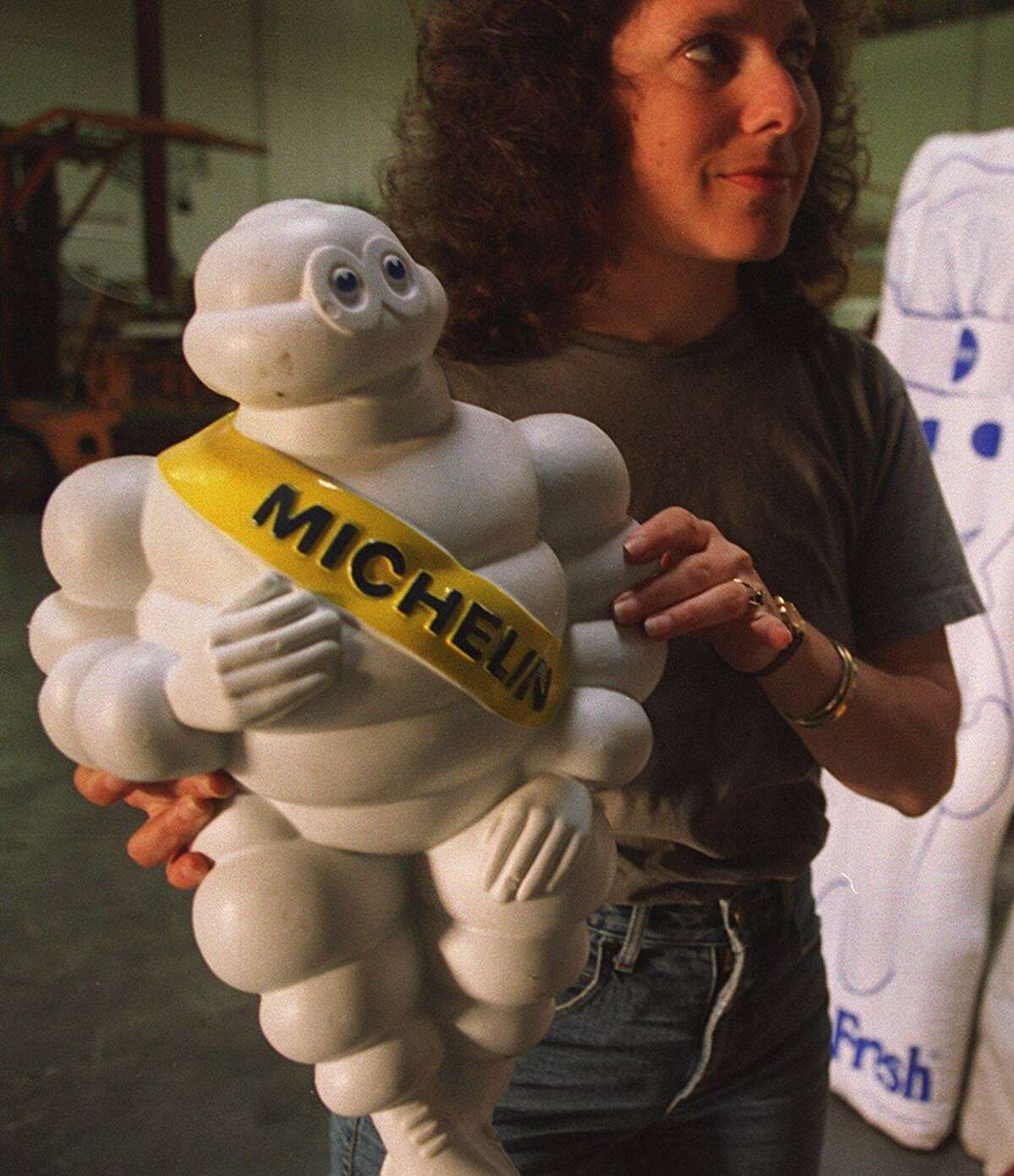 Ellen Weis holds a figurine of the Michelin Man at the Museum of Modern Mythology in San Francisco in 1996.