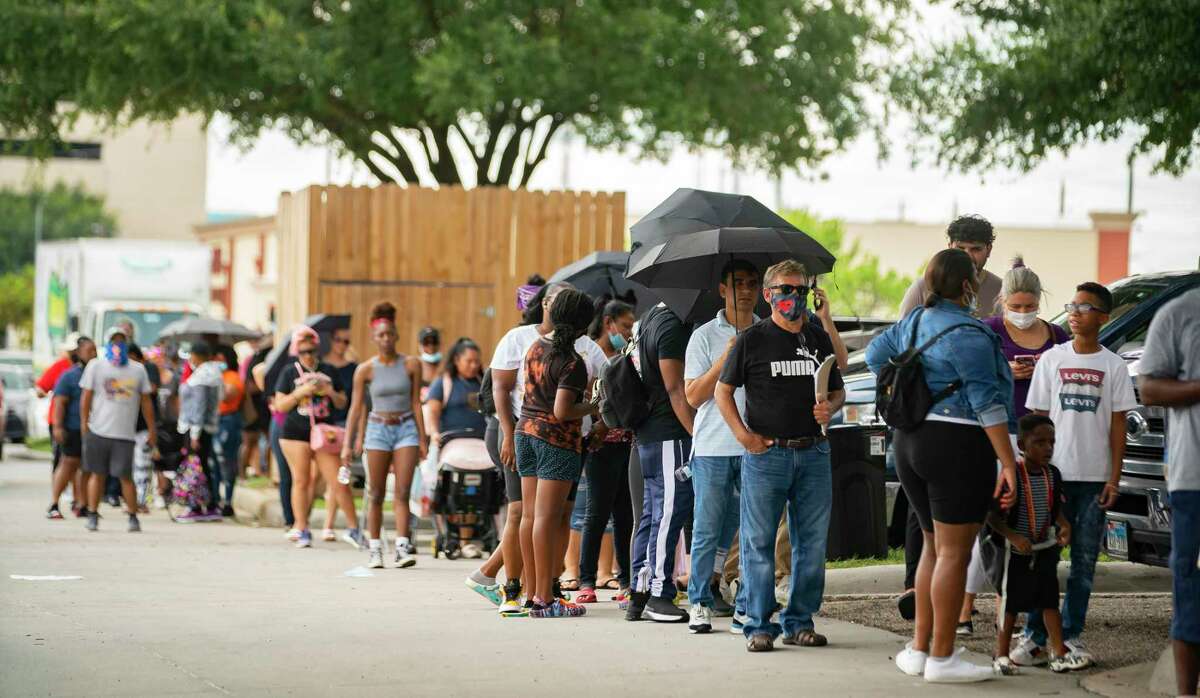 A line of people waiting for assistance applying for both the Harris County Recovery Assistance and the Houston-Harris County Emergency Rental Assistance program wait outside of the IBEW Local 716 building, Tuesday, Aug. 3, 2021, in Houston.
