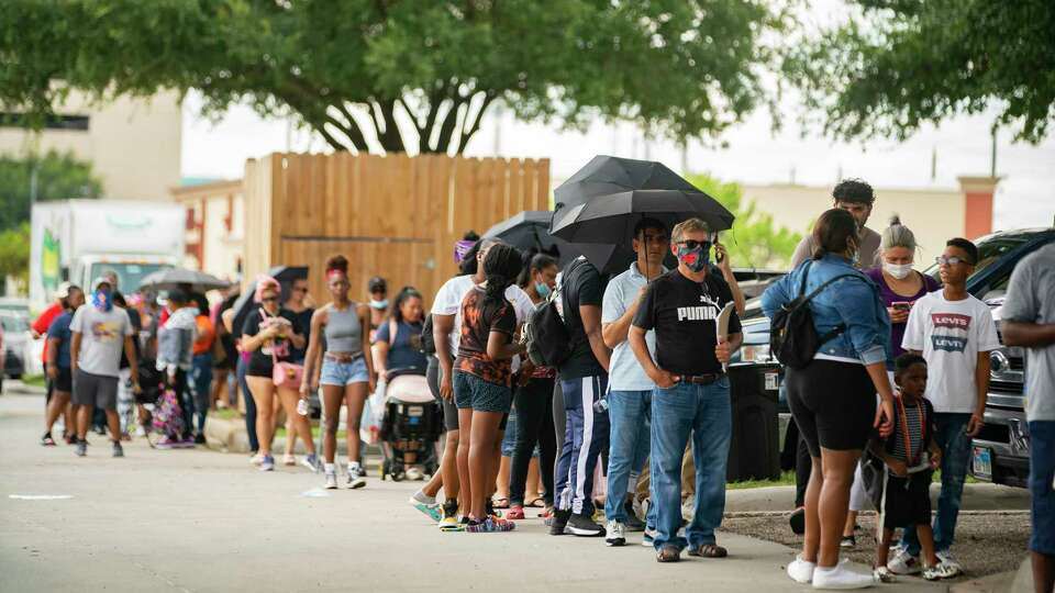 A line of people waiting for assistance applying for both the Harris County Recovery Assistance and the Houston-Harris County Emergency Rental Assistance program wait outside of the IBEW Local 716 building, Tuesday, Aug. 3, 2021, in Houston.