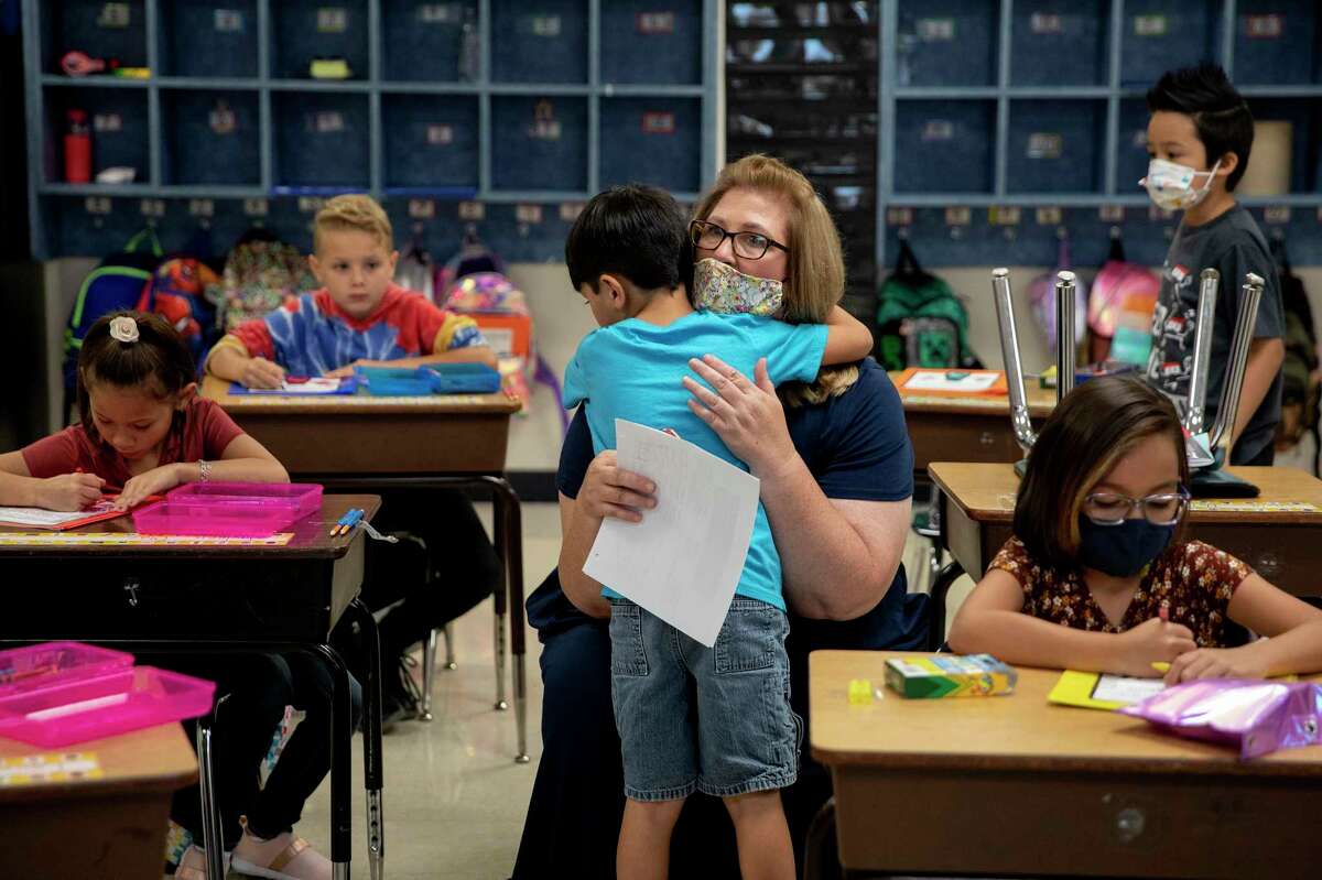 John James Cardenas, a second grader at Converse Elementary, hugs his principal, Cynthia Davis. The Judson ISD school switched to a year-round calendar to counter the learning loss aggravated by the pandemic — and now is among the first to open for the fall as schools lose their ability to reduce risk factors for new infections.