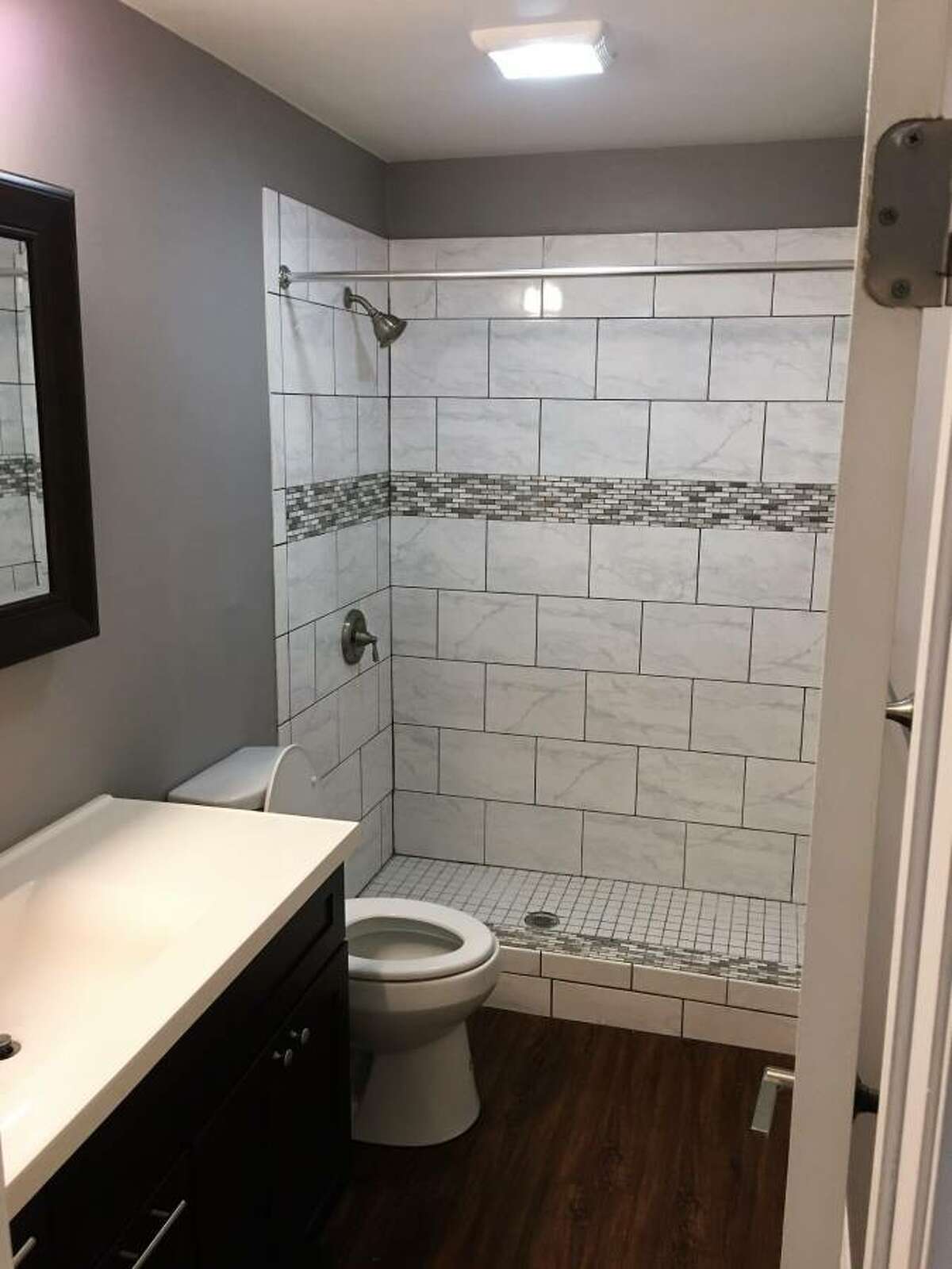 The refreshed look includes custom tile work in the bathroom.