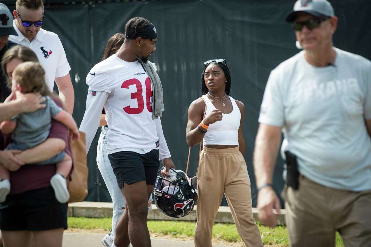 Olympic gymnast Simone Biles walks with her boyfriend Houston Texans defensive back Jonathan Owens (36) as she takes in Texans training camp football practice Friday, Aug. 6, 2021, in Houston.