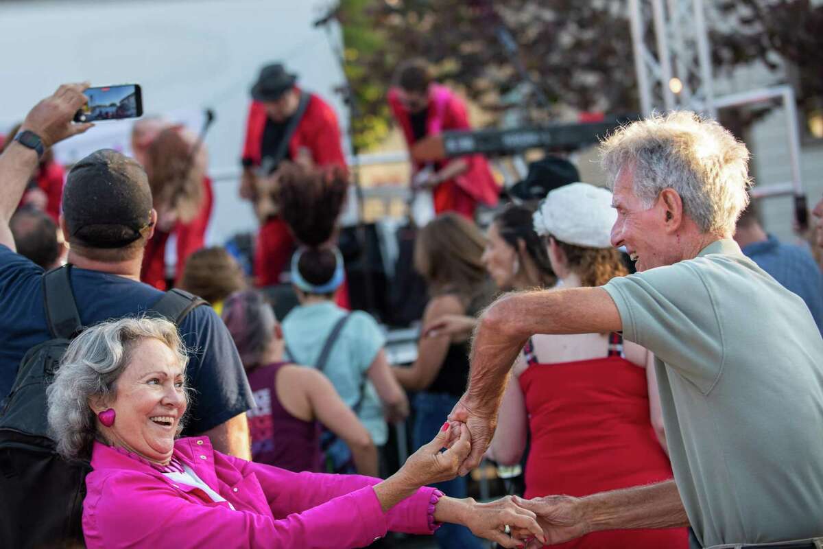 Cari Pace (left) and Bob Koch dance together while the Pop Rocks dance band performs on stage during Novato’s Rock the Block street party.