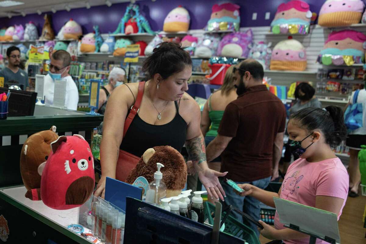 Bianca Ramirez and her daughter Isabella, 8, pay for the Squishmallows they recently bought the Learning Express store in the Alamo Quarry Market.