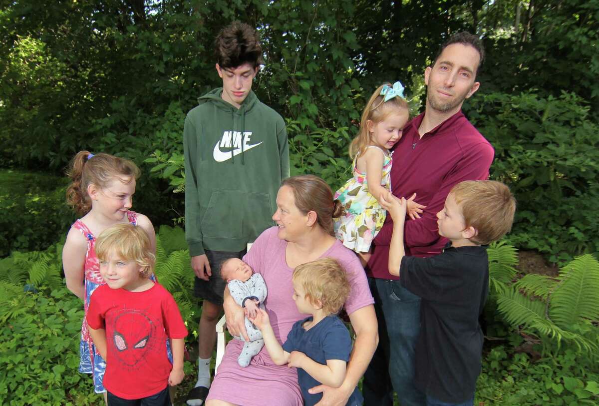 Members of the Zazula family pose together at their home in Greenwich, Conn., on Saturday July 31, 2021. From left to right is Rachael, 9, Daniel, 4, Zachary 14, Luke, one week old, mom Jena, Isaiah, 3, Samantha, 2, dad David, and Joshua, 6. Not present Elijah, 11. Even before COVID-19 hit, quality day care centers were in high demand. Now, with parents returning to work, it has been difficult for many to find childcare openings in the area.