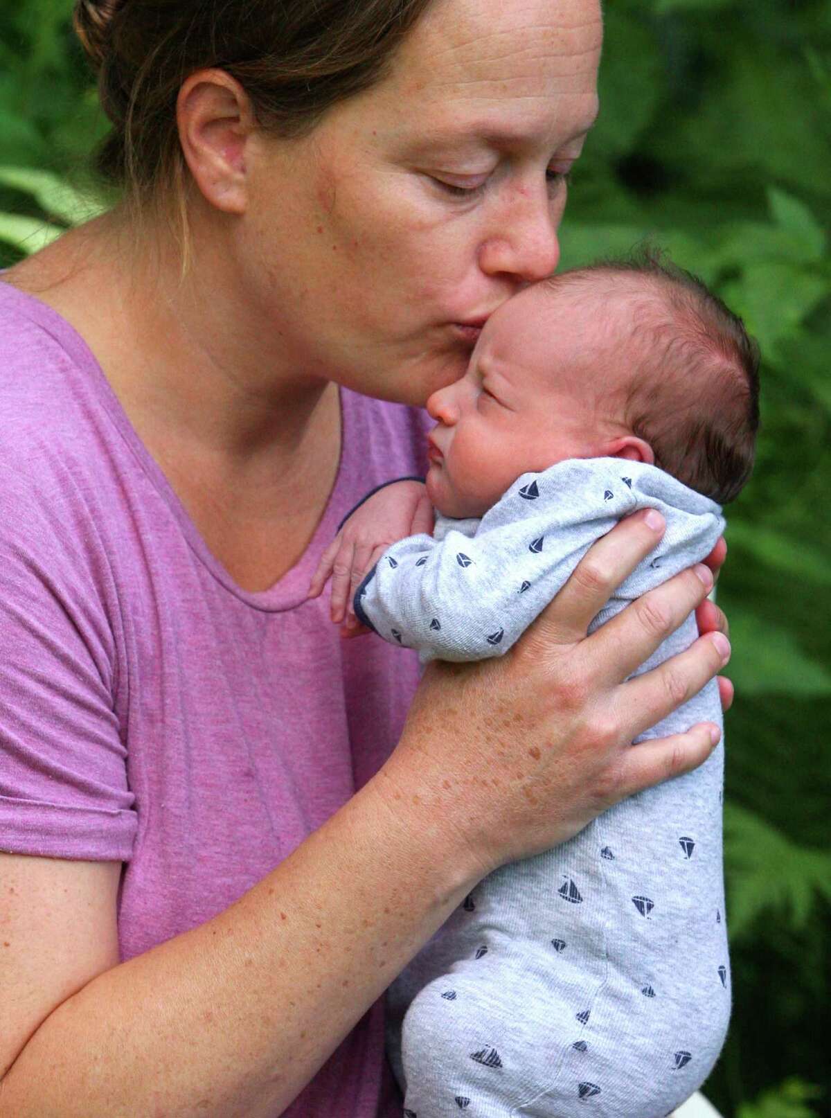 Jenn Zazula kisses her one-week-old son Luke at her home in Greenwich, Conn., on Saturday July 31, 2021. Even before COVID-19 hit, quality day care centers were in high demand. Now, with parents returning to work, it has been difficult for many to find childcare openings in the area.
