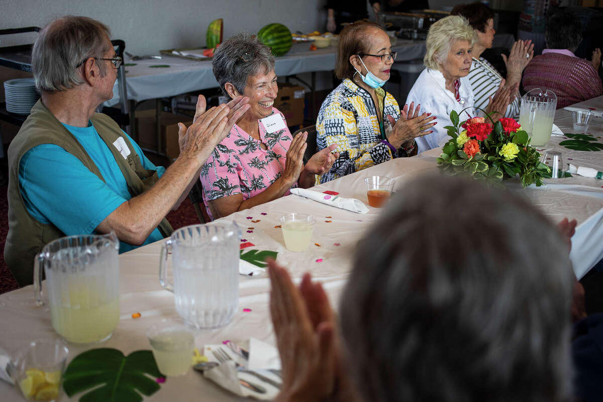 Diana Simmons, second from left, claps alongside other residents of Riverside Place Senior Living Community as they celebrate the anniversary of their return to the building with a catered meal Saturday, Aug. 7, 2021 in Midland. (Katy Kildee/kkildee@mdn.net)