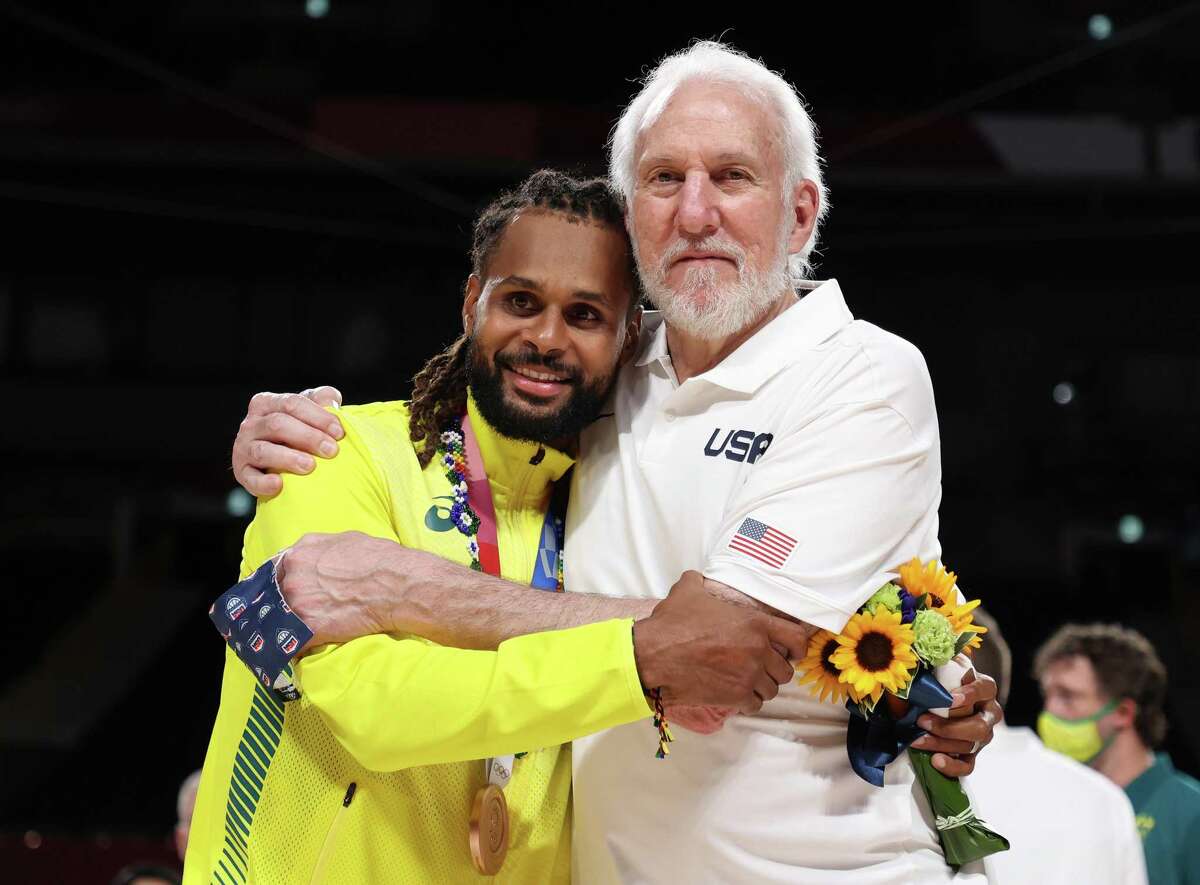 SAITAMA, JAPAN - AUGUST 07: Team United States Head Coach Gregg Popovich poses with Team Australia's Patty Mills during the Men's Basketball medal ceremony on day fifteen of the Tokyo 2020 Olympic Games at Saitama Super Arena on August 07, 2021 in Saitama, Japan. (Photo by Gregory Shamus/Getty Images)