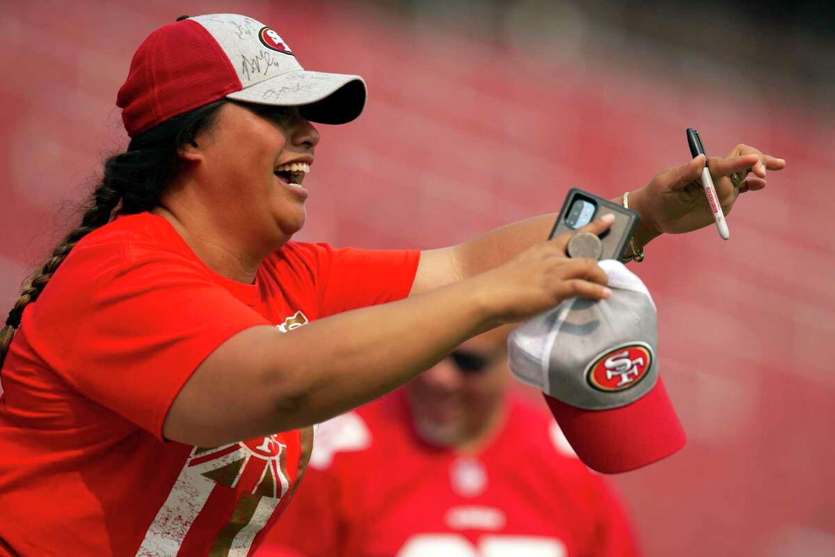 San Francisco 49ers fan Lydia Sakay of Salinas, Calif. cheers on her team as they enter Levi's Stadium for practice an NFL football training camp, Saturday, Aug. 7, 2021, in Santa Clara, Calif. (AP Photo/D. Ross Cameron)